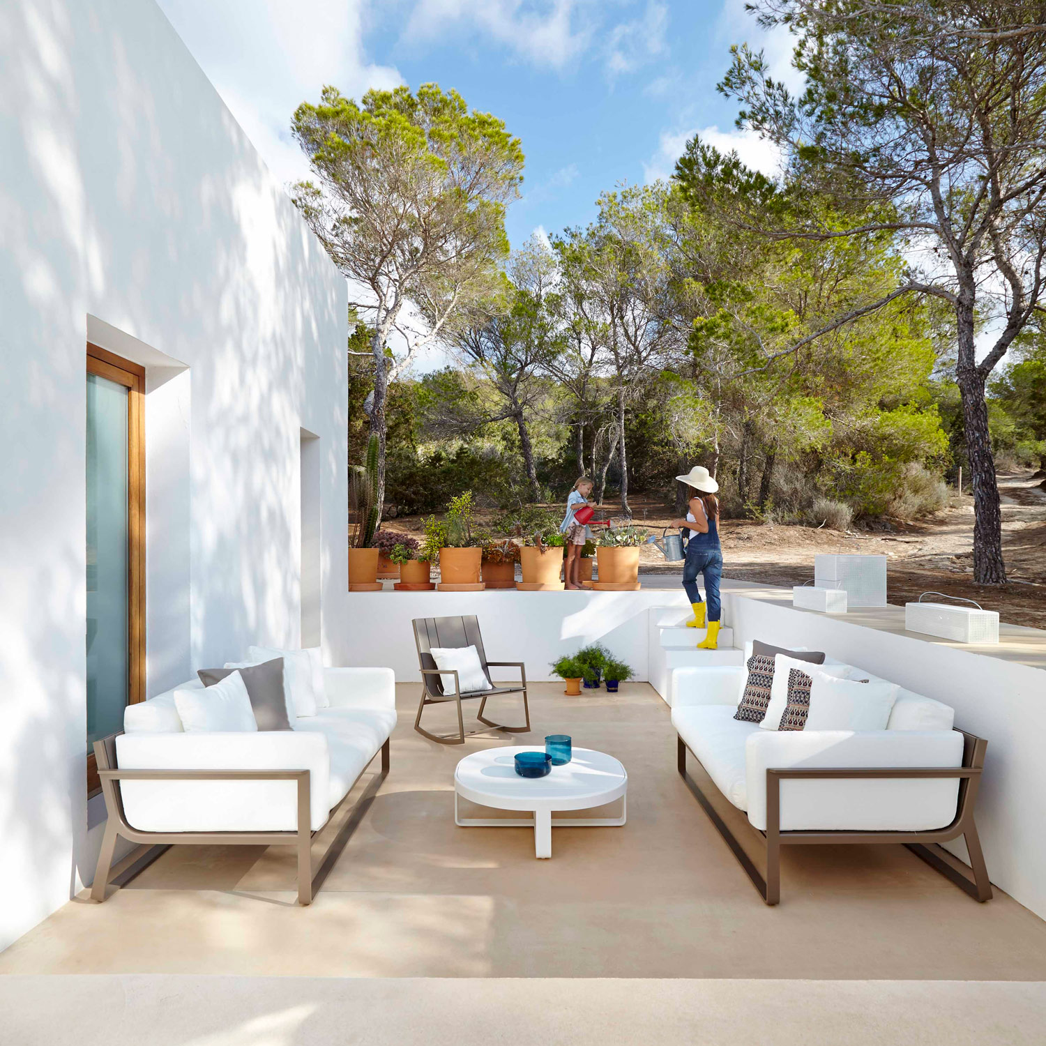 Flat loungemøbler i bronzelakering med hvide hynder på den skønne terrasse fra Gitz Design og Gandia Blasco
