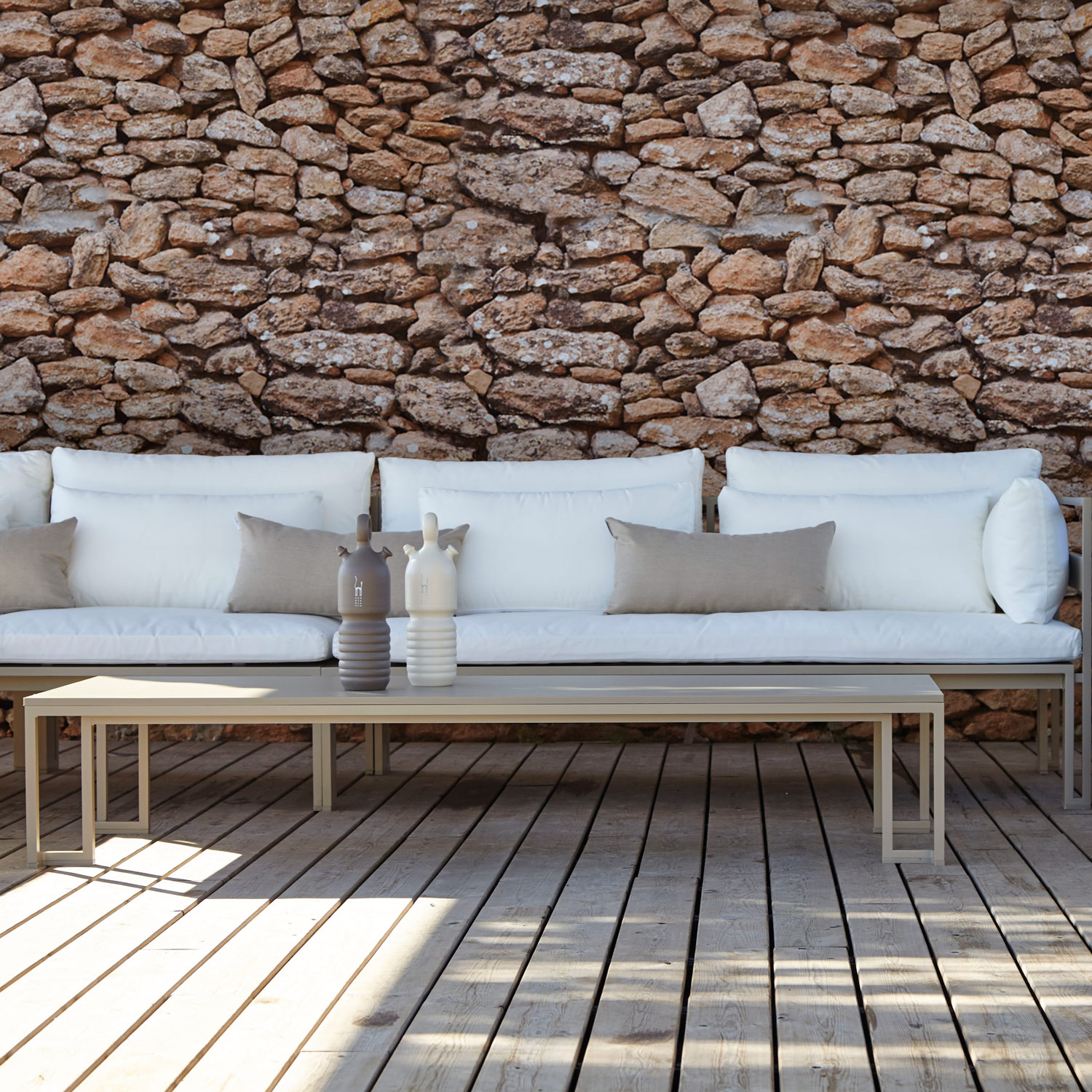 Jian chaiselong sofa med hvide hynder og det lave sofabord i sand fra Gitz Design og Gandia Blasco