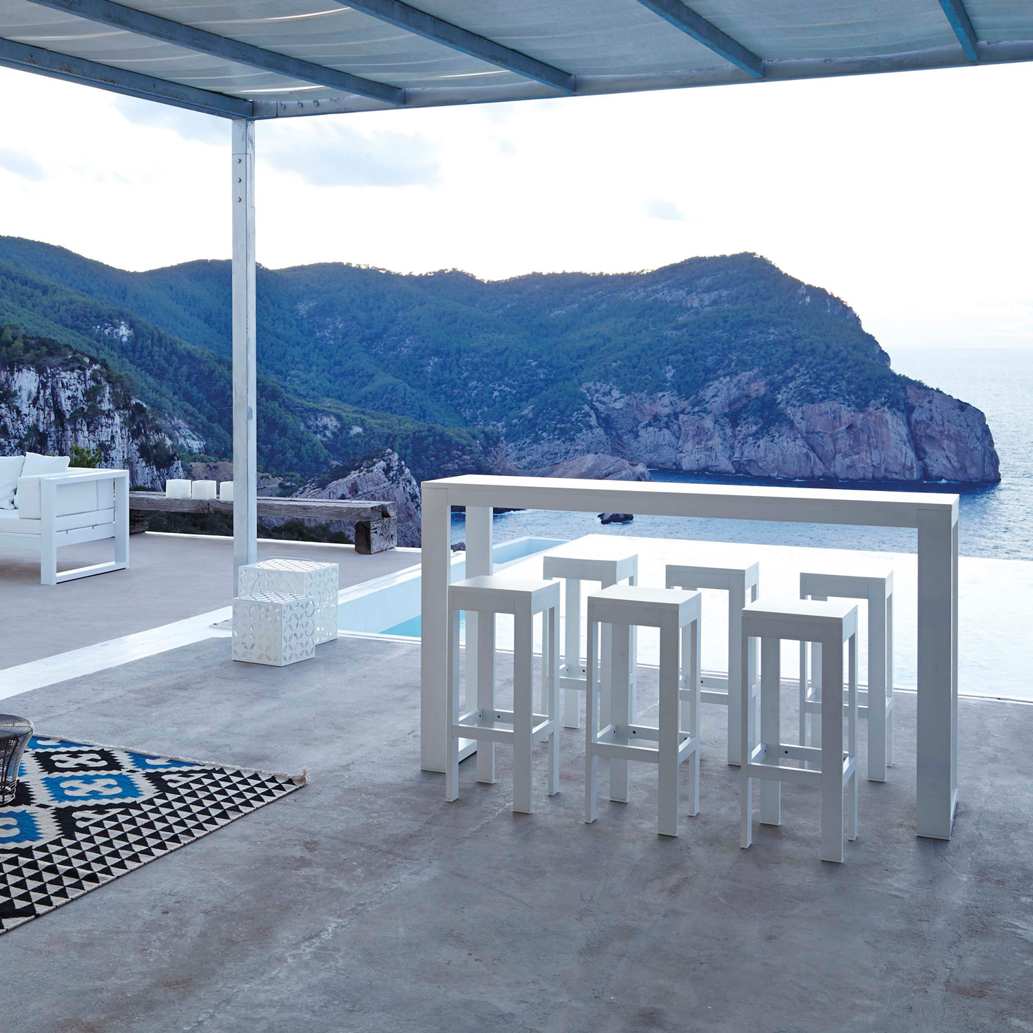 Na Xemena havemøbler loungesæt og det minimalistiske barbord med barstole i hvidt fra Gitz Design og Gandia Blasco